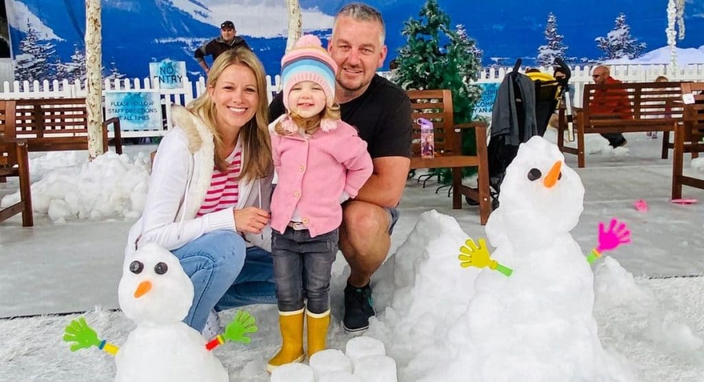 Family next to a snowman at Snow4Kids