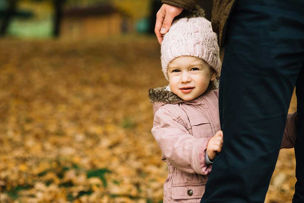 Shy Child Hiding Behind Parent's leg