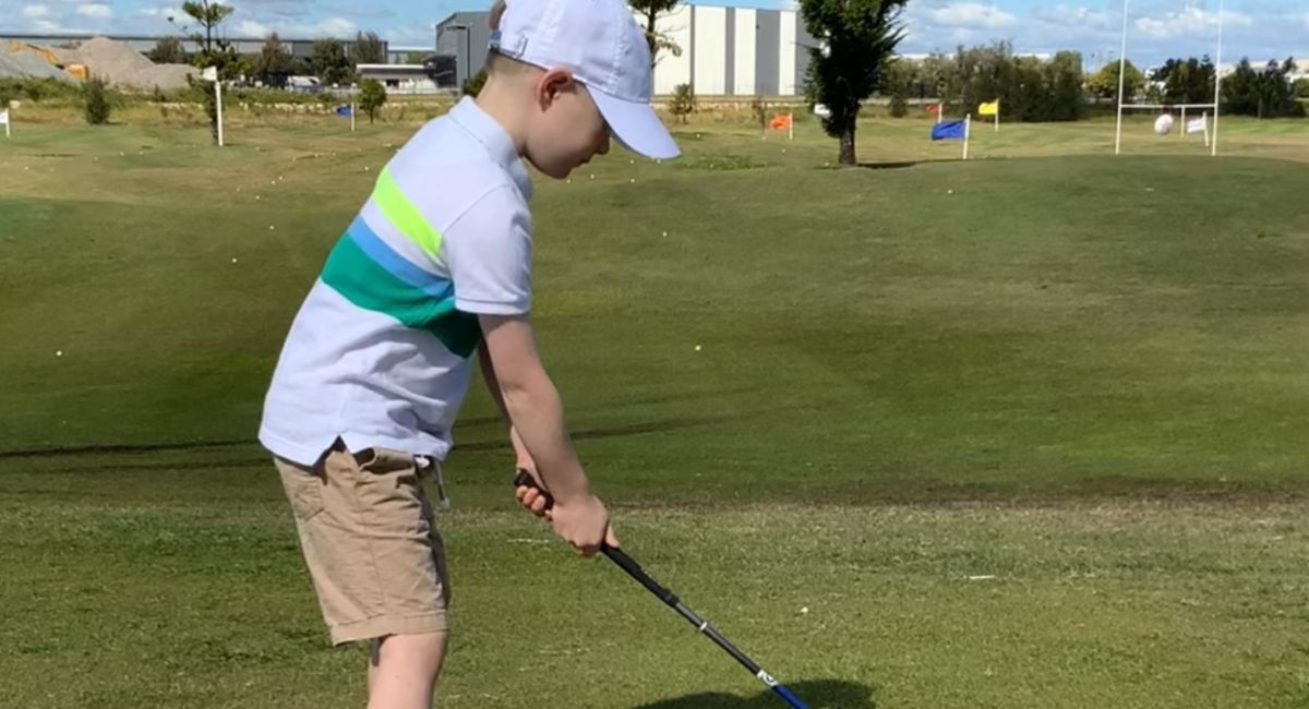 Little Boy Learning to Play Golf at Golf Bne Junior Golf Clinic