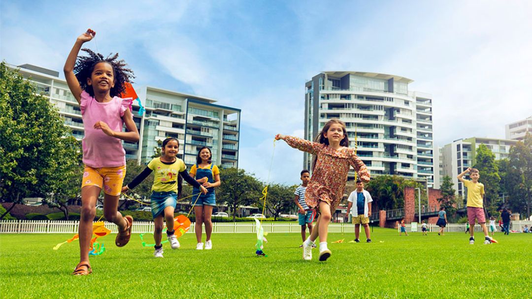 Kids Running Across Grass at Kids Collective Roma Street Parklands