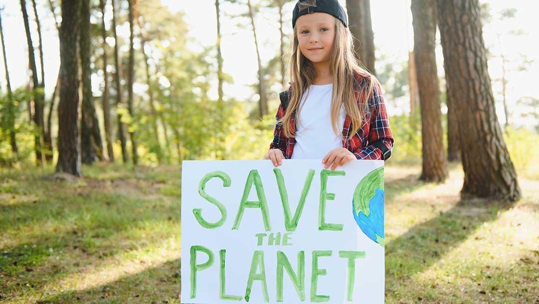 Girl Holding Save the Planet Sign for Earth Month