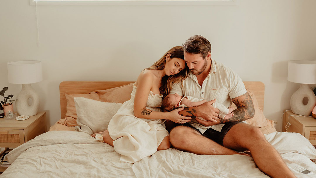 New Parents Happily Cuddling Baby
