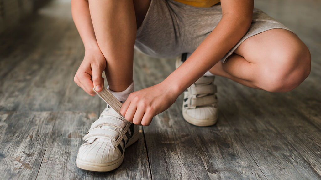 Child-with-velcro-shoes | Kids in Brisbane, Gold Coast, Sunshine Coast | Kotc Child Fastening Velcro Shoes