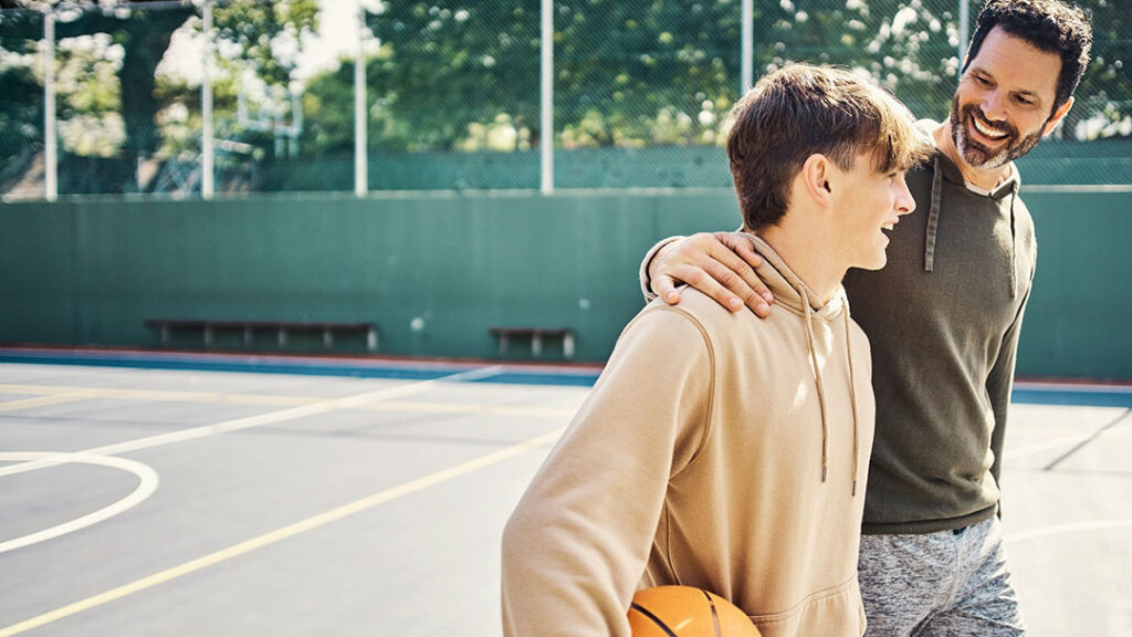 Dad with Teen Son Playing Basketball