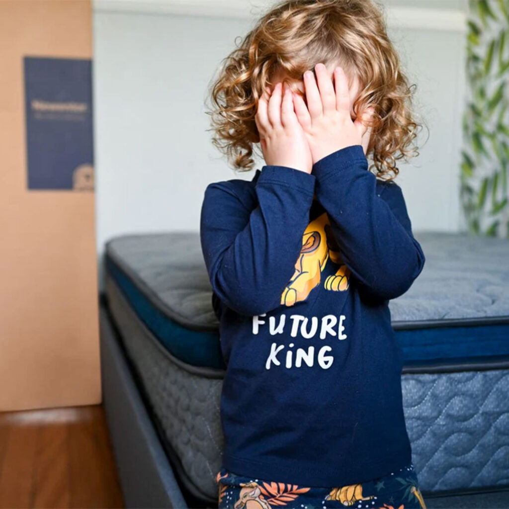 Kid Standing in Front of New Mattress