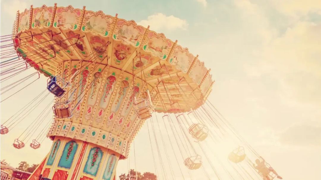 Colorful swing ride at an amusement park spinning under a bright sky