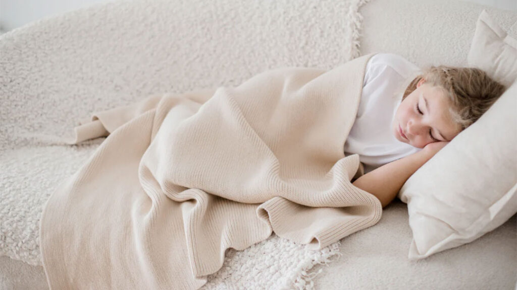 Child Asleep on Couch Under a Woven Woven Weighted Blanket