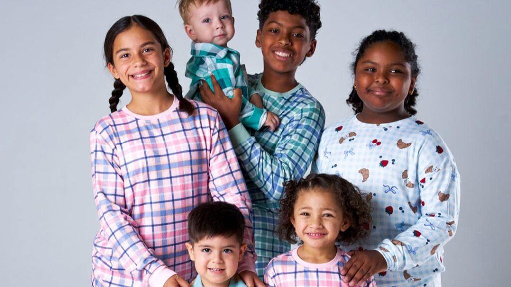 0514_nationalpyjamaday_2026_hero | Kids in Brisbane, Gold Coast, Sunshine Coast | Kotc Group of Six Smiling Children of Diverse Ages Posing Together Against a Light Gray Backdrop.