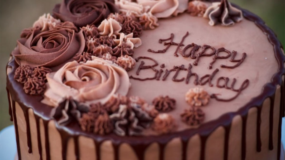 Kids-birthday-party-cake | Kids in Brisbane, Gold Coast, Sunshine Coast | Kotc Chocolate Birthday Cake with'Happy Birthday' inscription and chocolate rosettes along the edge.