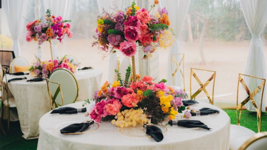 Kids-birthday-party-table | Kids in Brisbane, Gold Coast, Sunshine Coast | Kotc Round Banquet Table with a Tall, Vibrant Flower Centerpiece in a White-tented Setting.