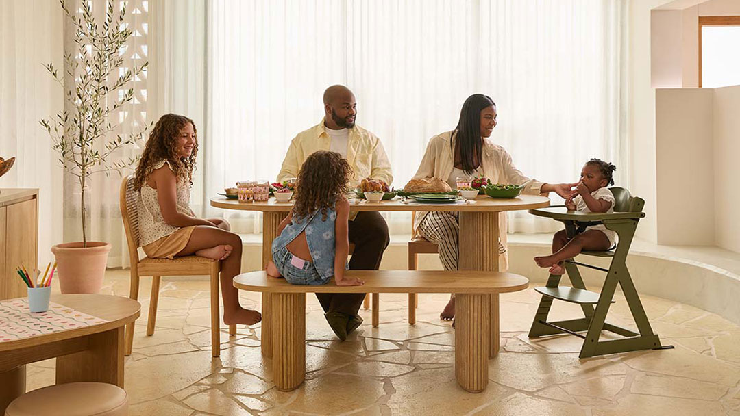 a Family of Five Sits Around a Round Wooden Dining Table from the Mocka Store Enjoying a Meal.