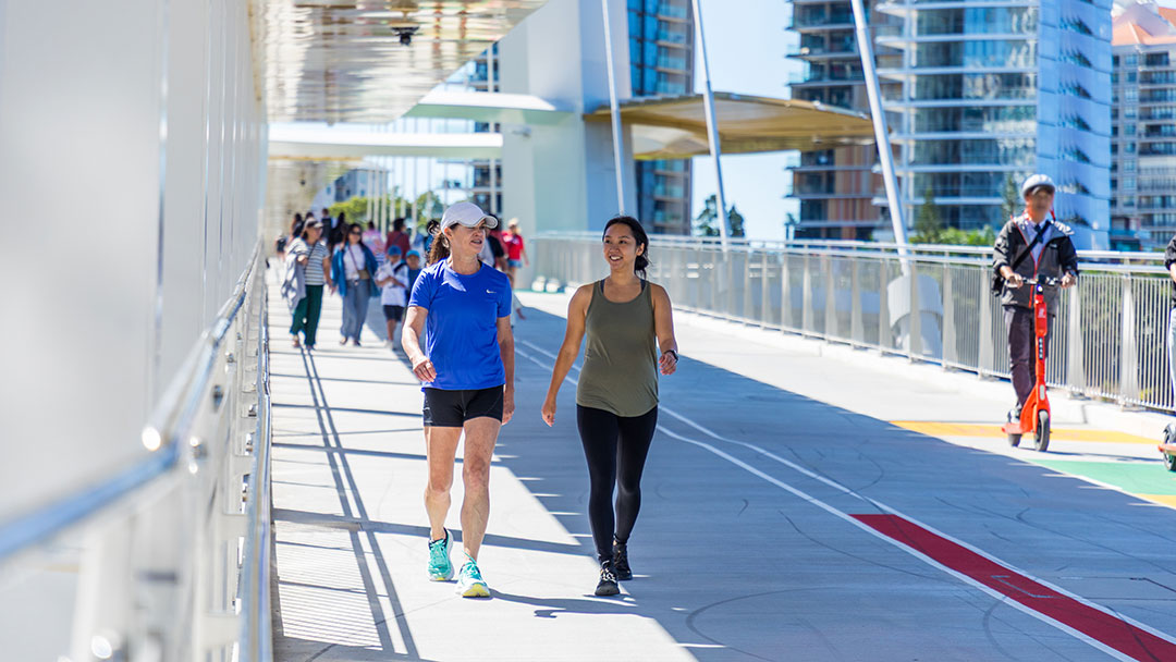 Best-brisbane-walks_kangaroo-point-bridge-1 | Kids in Brisbane, Gold Coast, Sunshine Coast | Kotc Two Women Walking on Kangaroo Point Bridge in Brisbane - Best Brisbane Walks for Kids