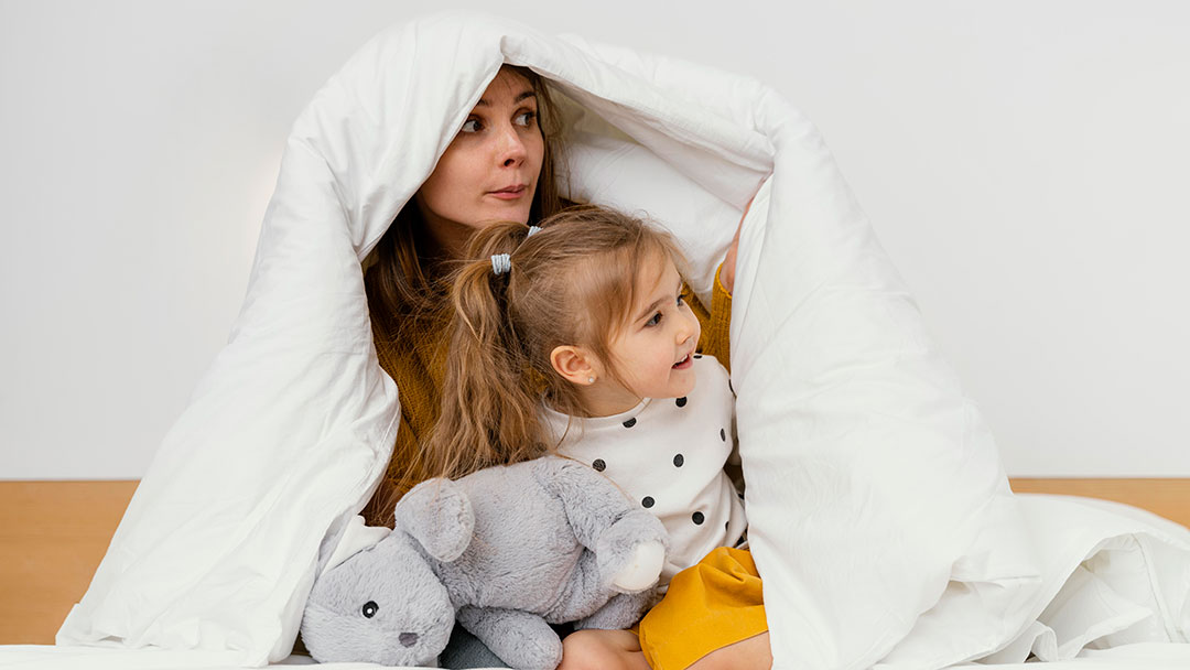 Mum and Daughter Staying Warm in a Blanket in Winter