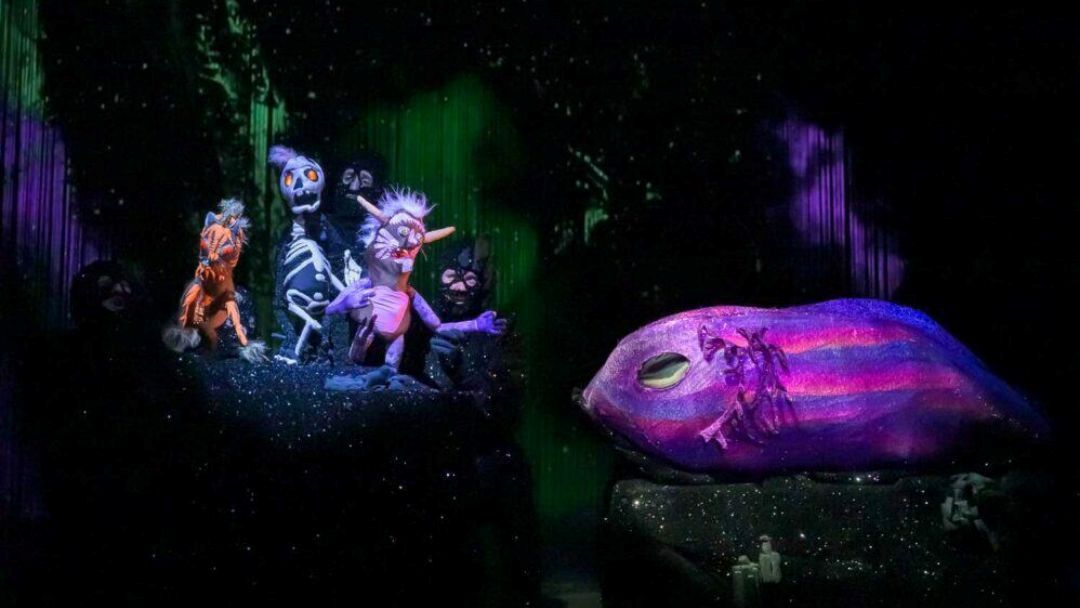0804_brisbanepowerhouse_dodo_hero | Kids in Brisbane, Gold Coast, Sunshine Coast | Kotc Colorful Puppets Illuminated on a Dark Stage Beside a Large Glowing Purple Fish Prop.