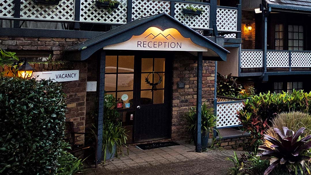 Hotel Reception Entrance with a Brick Facade, Arched Sign Reading Reception, and a'VACANCY' sign on the left wall.
