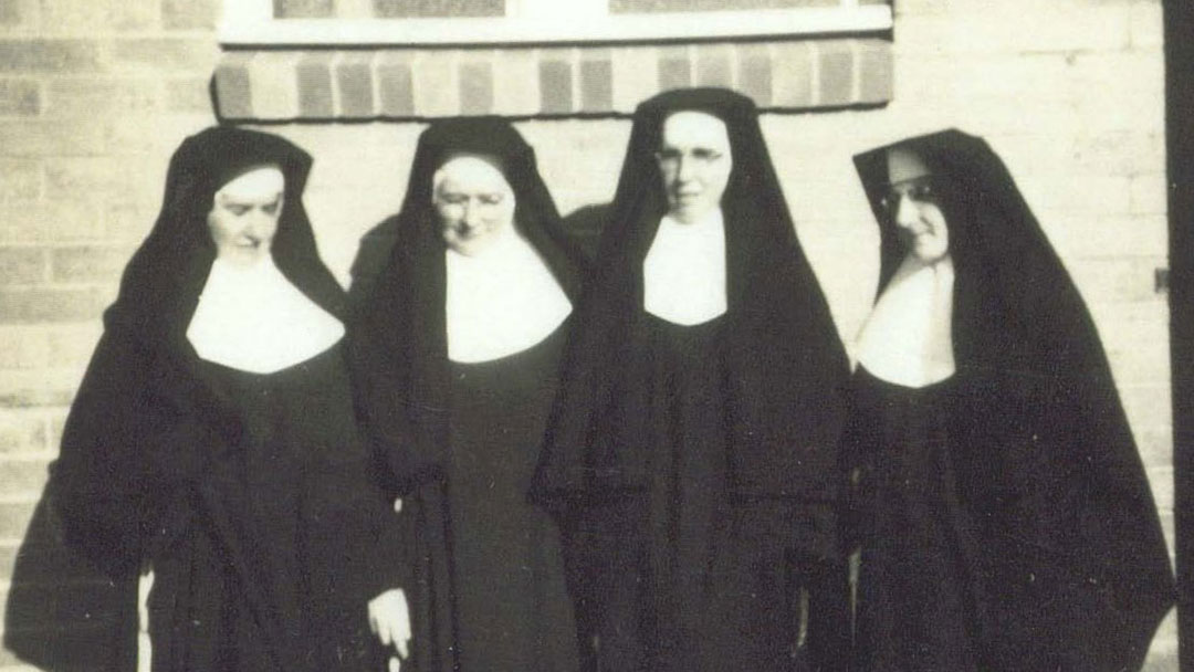 Mount-alvernia-college-sisters-1956 | Kids in Brisbane, Gold Coast, Sunshine Coast | Kotc Four Nuns in Black Habits and White Wimples Stand Together Outside a Brick Building, Smiling at the Camera.
