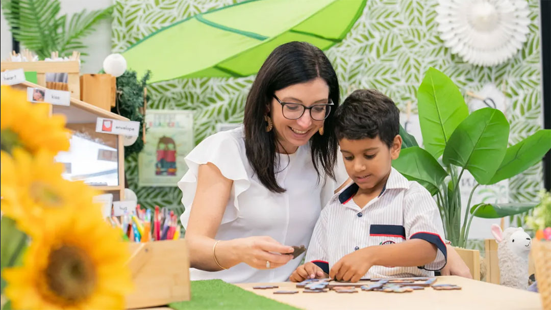 The-lakes-college-classroom | Kids in Brisbane, Gold Coast, Sunshine Coast | Kotc Woman and Young Boy Sorting Small Circular Tokens at a Bright Craft Table in a Classroom Setting