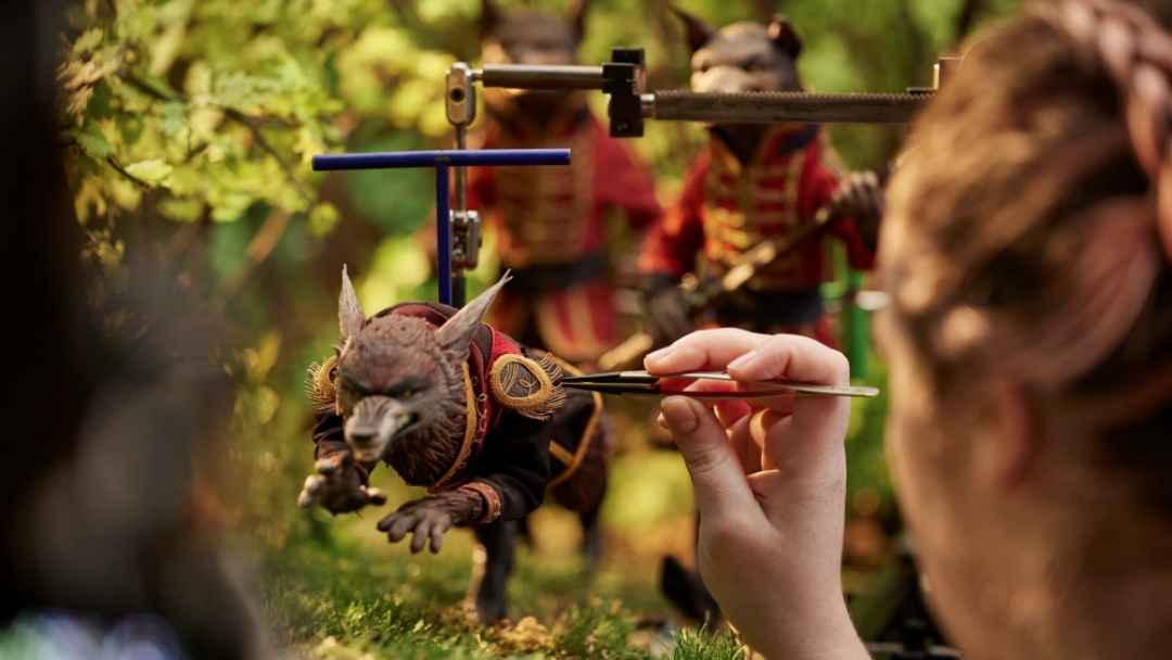 Behind-the-scenes View of a Laika Animator Using a Precision Tool to Adjust a Small Animal Puppet Suspended on a Support Rig on the Wildwood Forest Set.