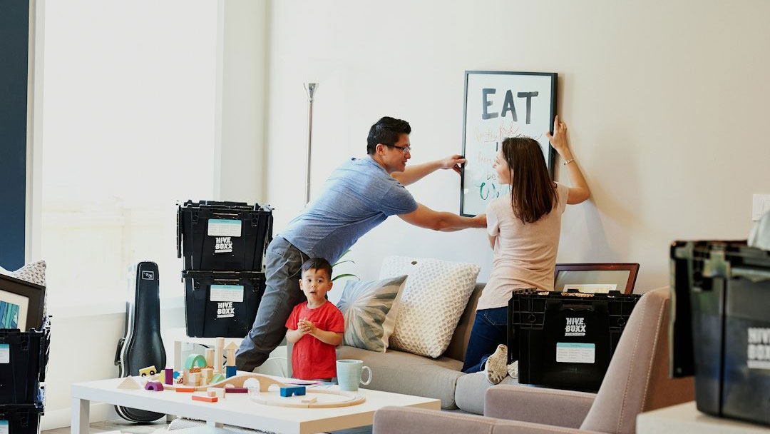 Family Hanging Picture on Wall of Their New Home
