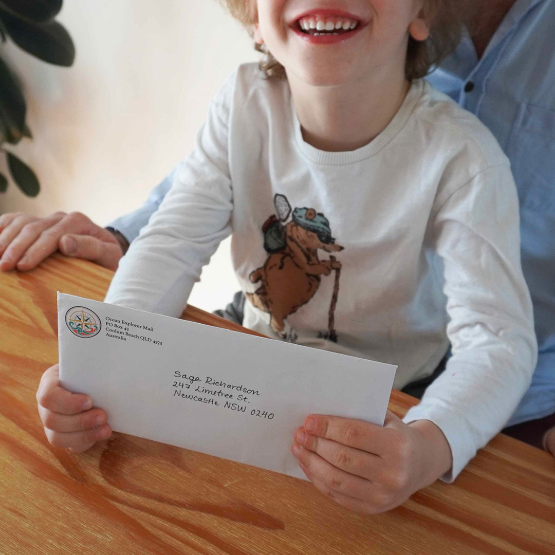 Happy Child Holding Ocean Explorers Mail