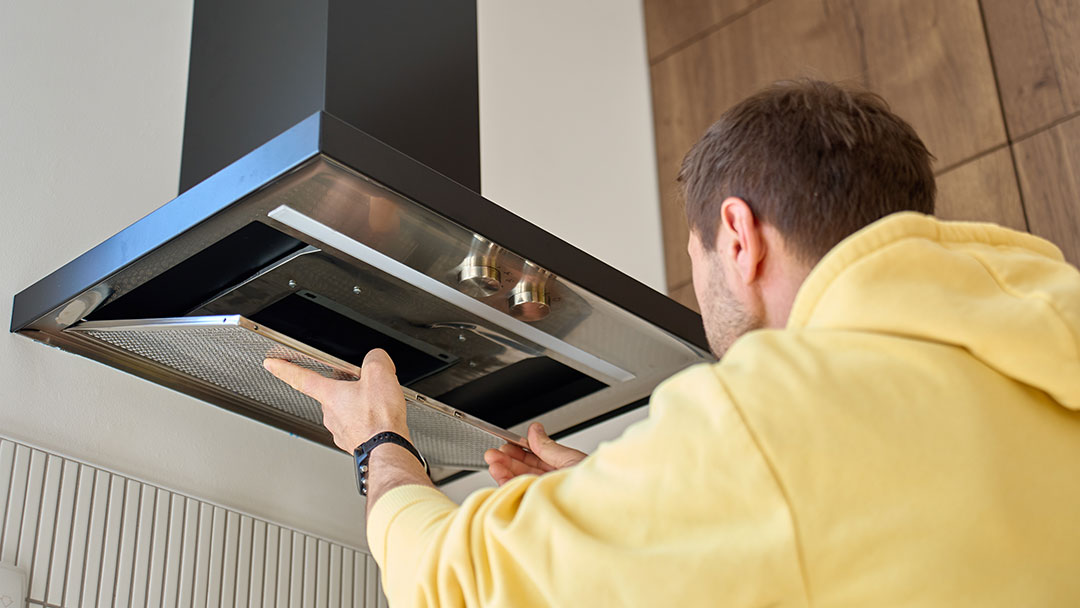 Person-fixes-rangehood | Kids in Brisbane, Gold Coast, Sunshine Coast | Kotc Person Removes Filter from Kitchen Rangehood